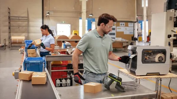 Man pulling label from RFID printer on manufacturing plant floor