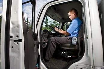 Man in truck looking at mobile device